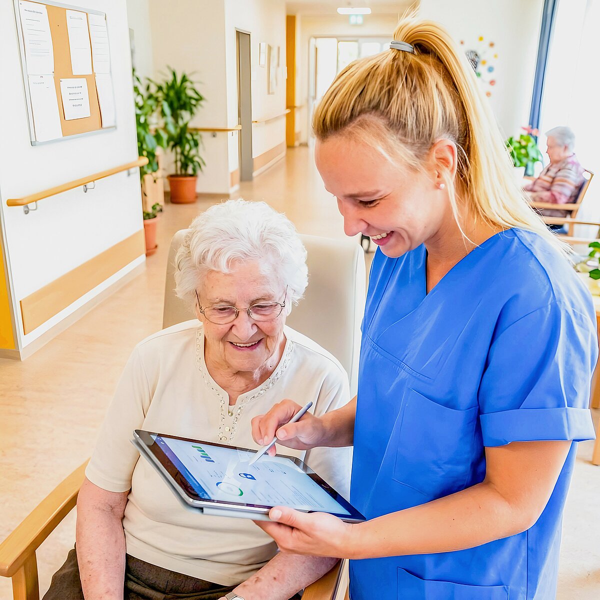 Pflegerin und Seniorin am Tablet