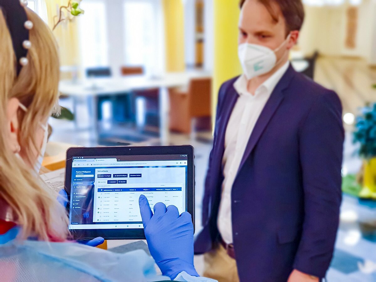 Pflegekraft bei Alloheim nutzt Tablet zur Erfassung von Corona-Schnelltests