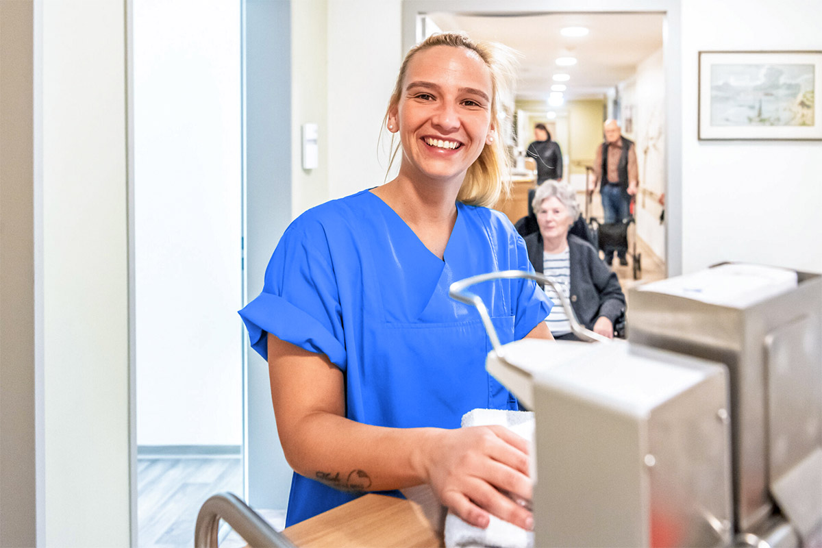 Pflegerin im Flur einer Alloheim Seniorenresidenz