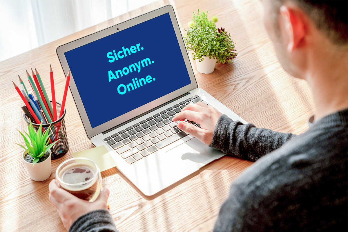 Mann sitzt vor Laptop